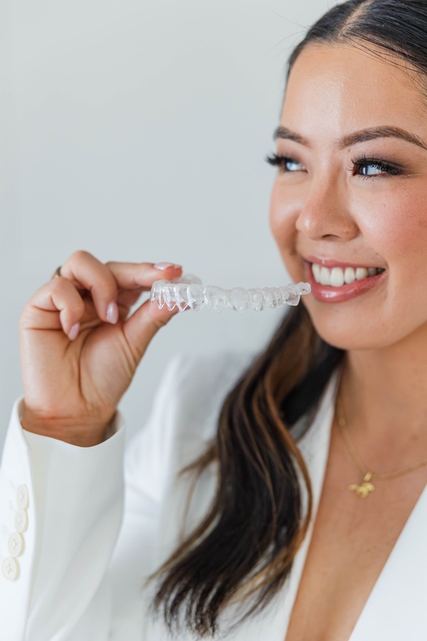 Dr. Alice Xiang holding an Invisalign clear aligner
