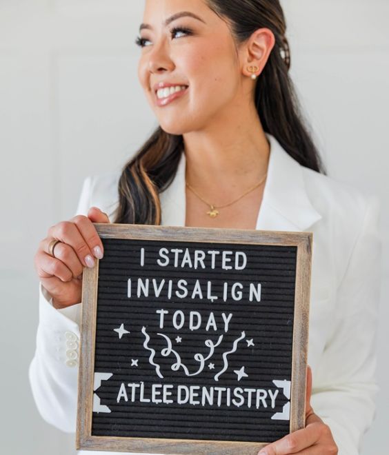 Dr. Alice holding an "I Started Invisalign Today" letter-board sign