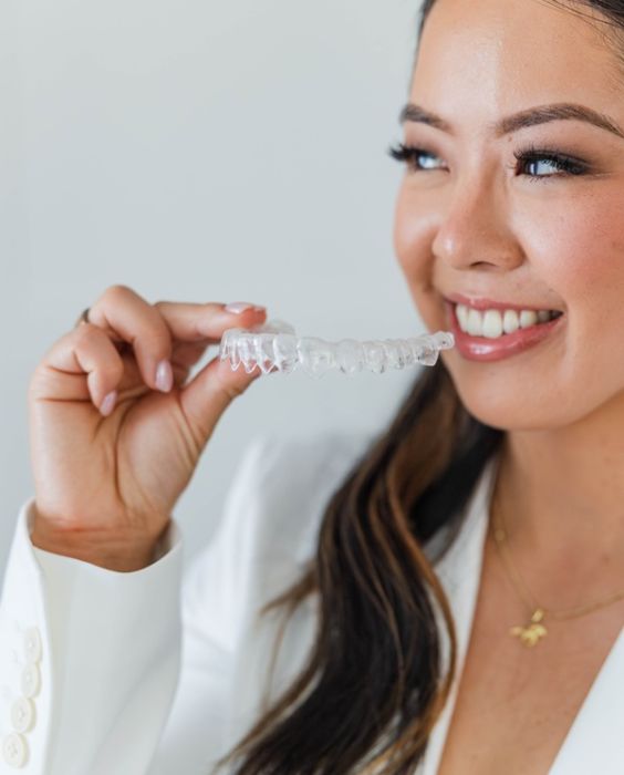 Dr. Alice with an Invisalign aligner (placeholder — replace with sleek-hair shot)